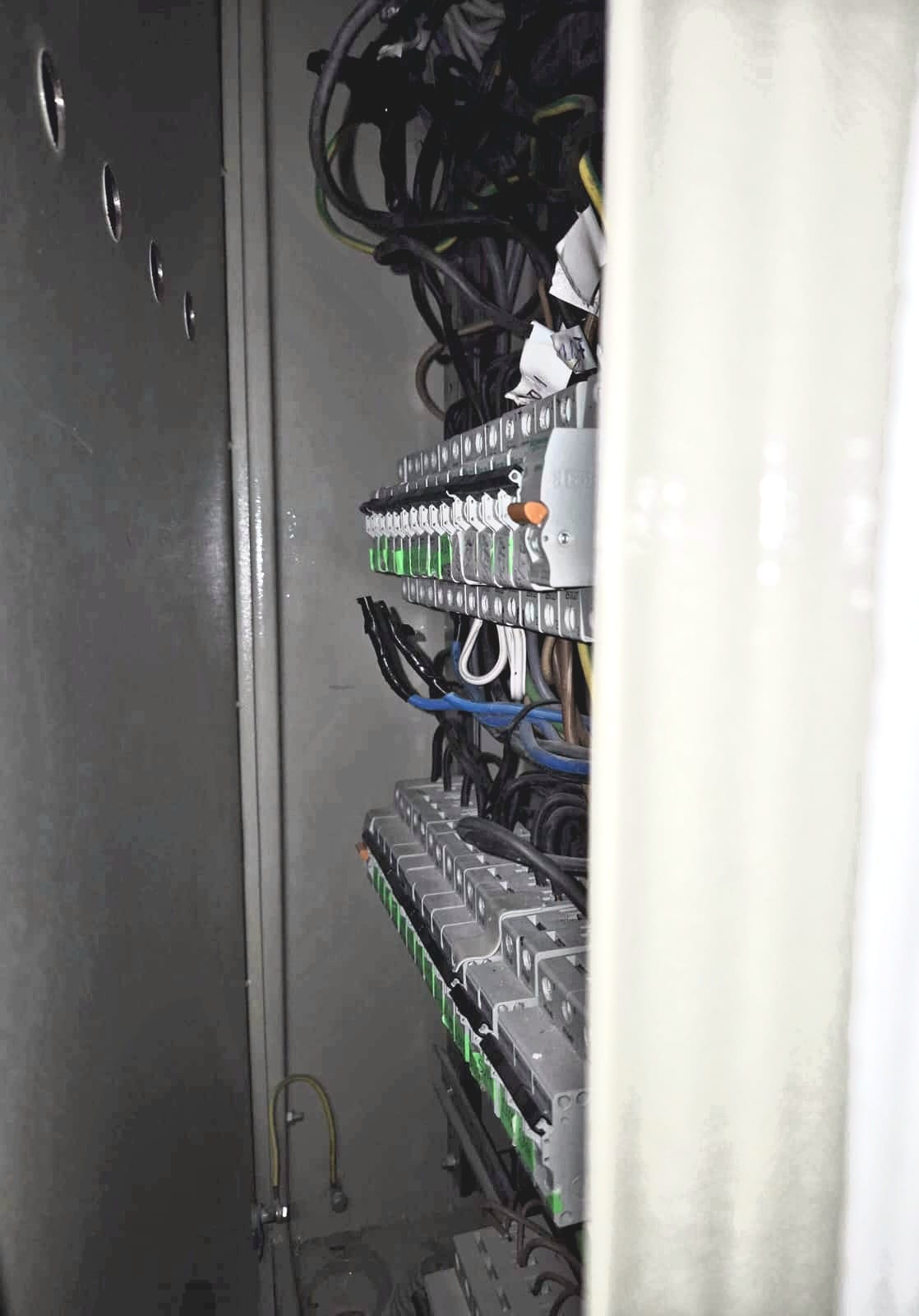 Offener Elektroverteilerkasten mit Sicherungen in einem Hotelgeschoss